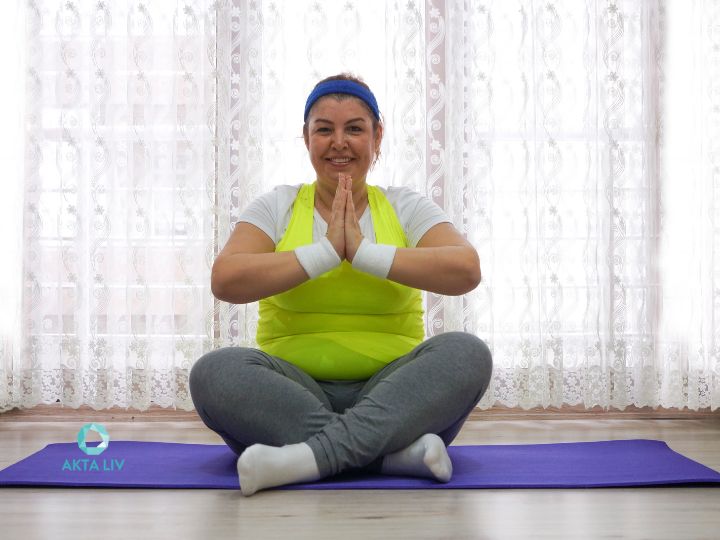 Problemas hormonais. Mulher obesa sorridente enquanto medita em um tapete de yoga.
